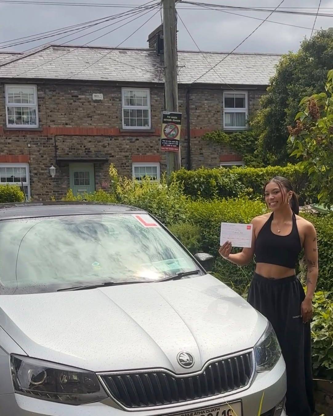 A learner driver and a certified instructor in Tallaght smiling while reviewing a flexible, no-hidden-fee driving lesson package brochure.