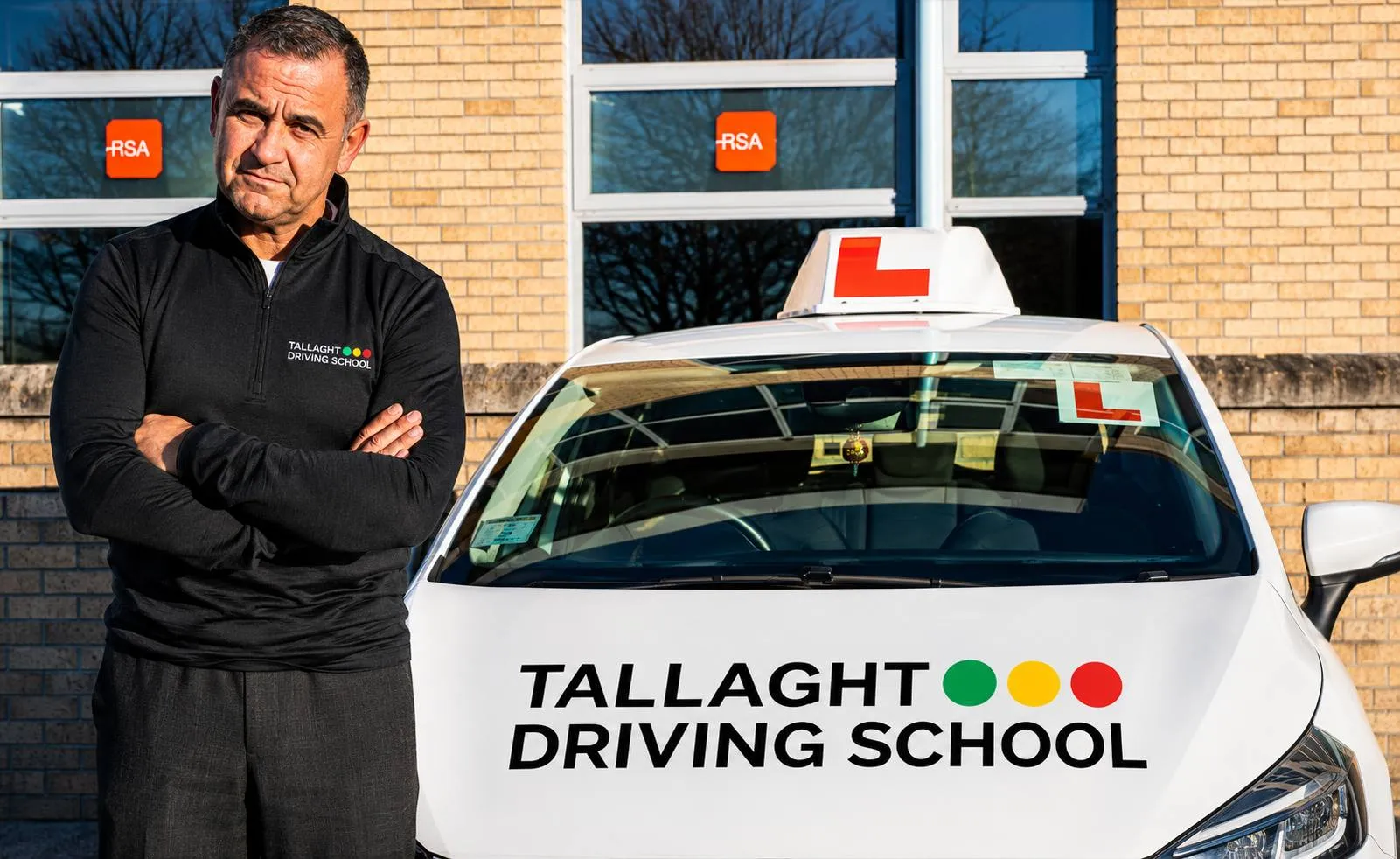 A learner driver and an RSA approved instructor reviewing an Essential Driver Training logbook before a driving lesson.